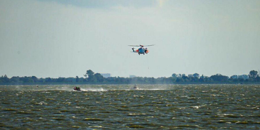 Er wordt met een helikopter en reddingboten gezocht naar de drenkeling.
